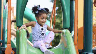 little girl playing on playground equipment - childrenswear